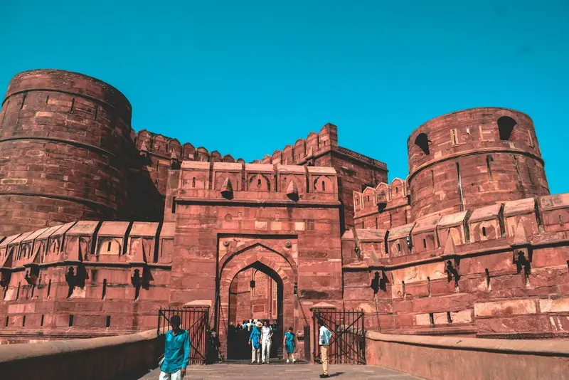 Visitors at the Amar Singh Gate of Agra Fort under a blue sky