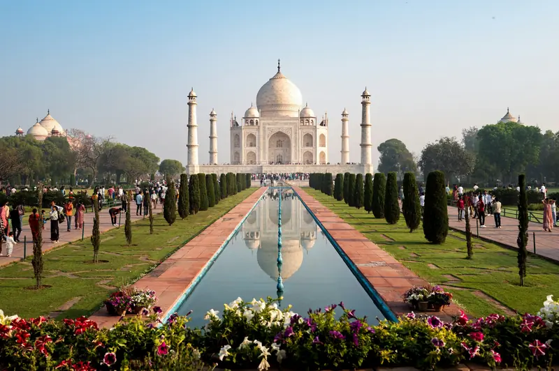 The Taj Mahal reflected in the long water channel of its flower-lined Mughal garden