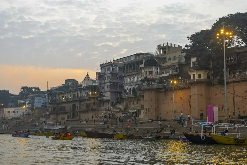 Riverside buildings of Varanasi at dusk with boats on the Ganges