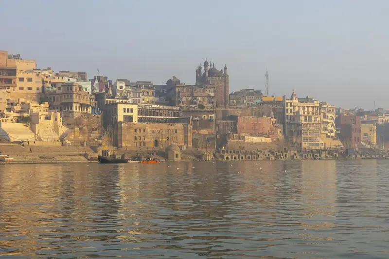 The Varanasi riverfront in soft morning haze across the Ganges