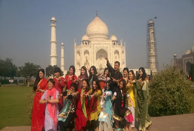 Group of women in colourful saris in front of the Taj Mahal
